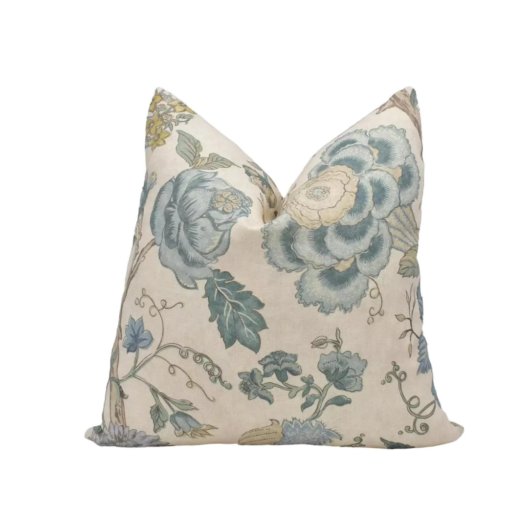 a decorative pillow with a floral pattern in shades of blue and green.