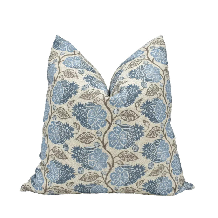 A decorative throw pillow with a floral pattern in shades of blue and brown.