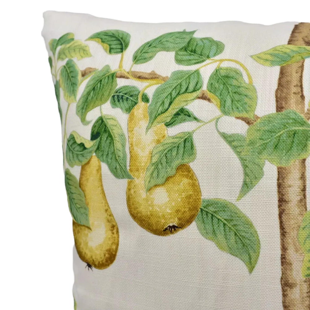 A close-up image of a decorative pillow with a design featuring two pears hanging from a branch with green leaves.
