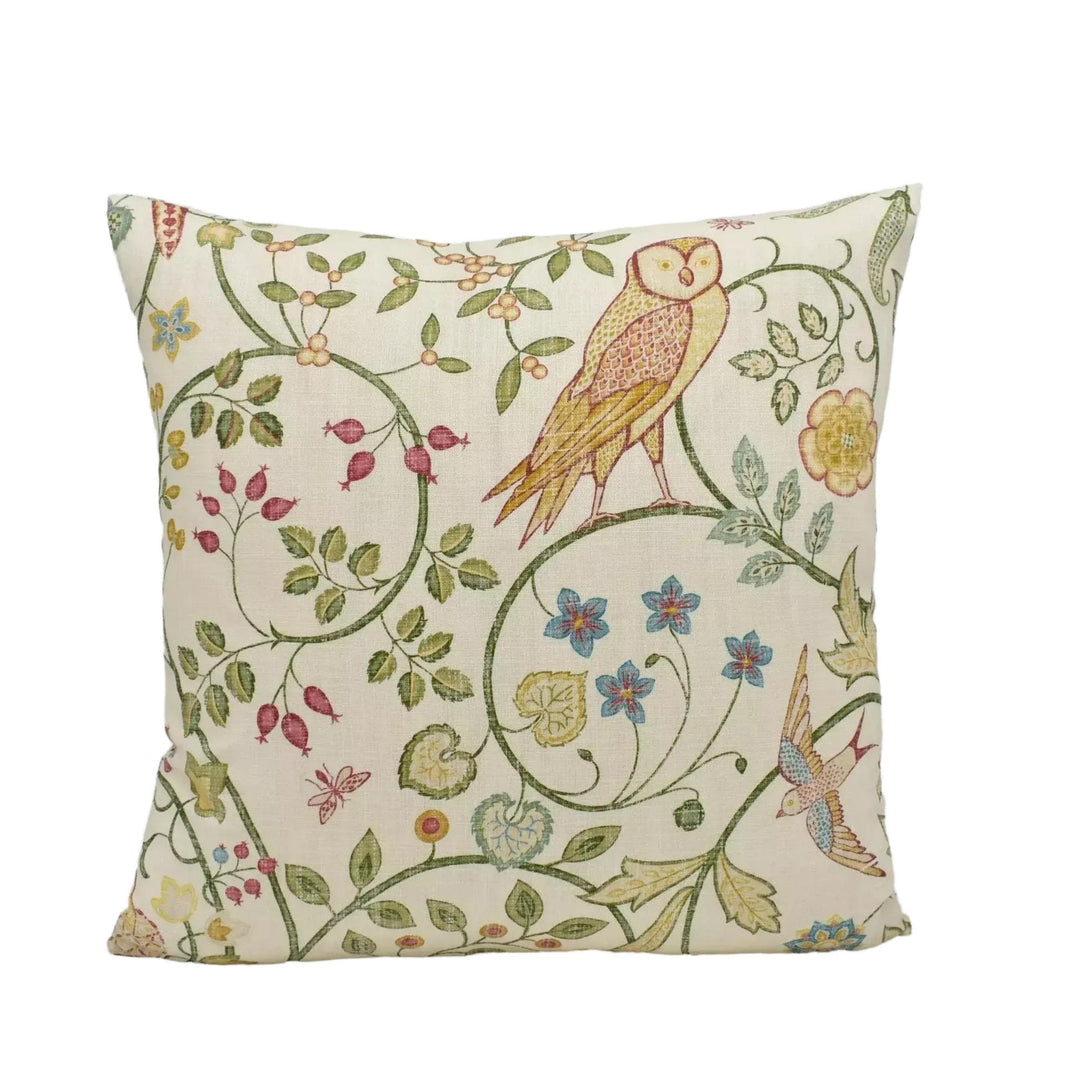 A decorative throw pillow with a floral and bird motif.
