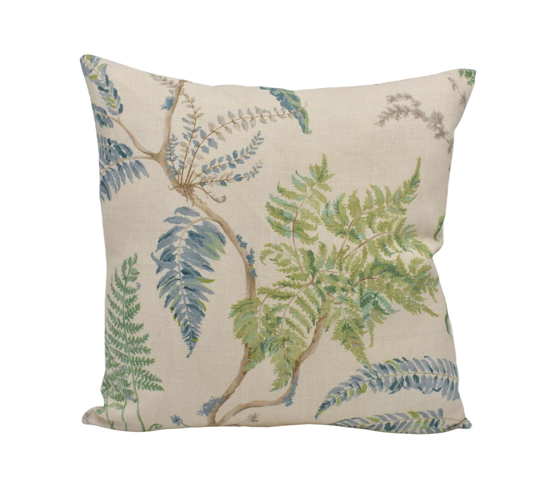 A square throw pillow with a floral print design featuring green ferns and other foliage.