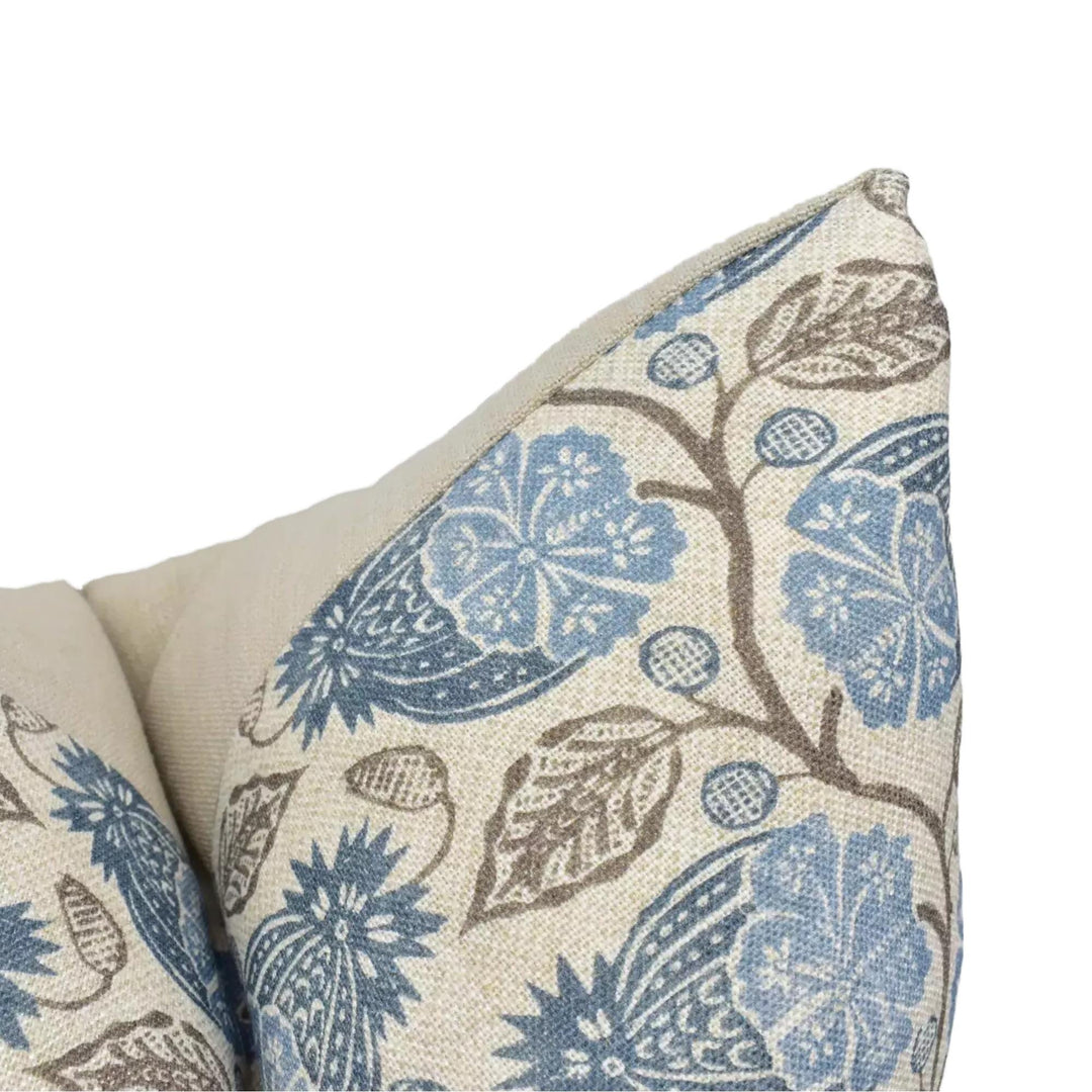 a close-up view of a decorative pillow with a floral pattern in shades of blue and brown.
