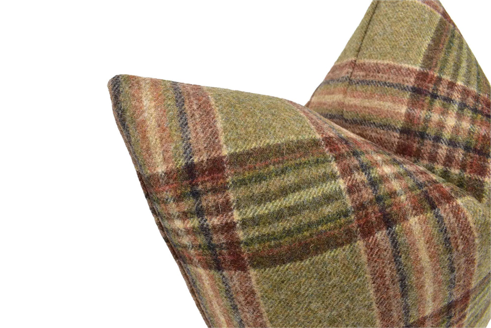 A close-up view of a plaid pillow with a checkered pattern in shades of green, brown, and red.