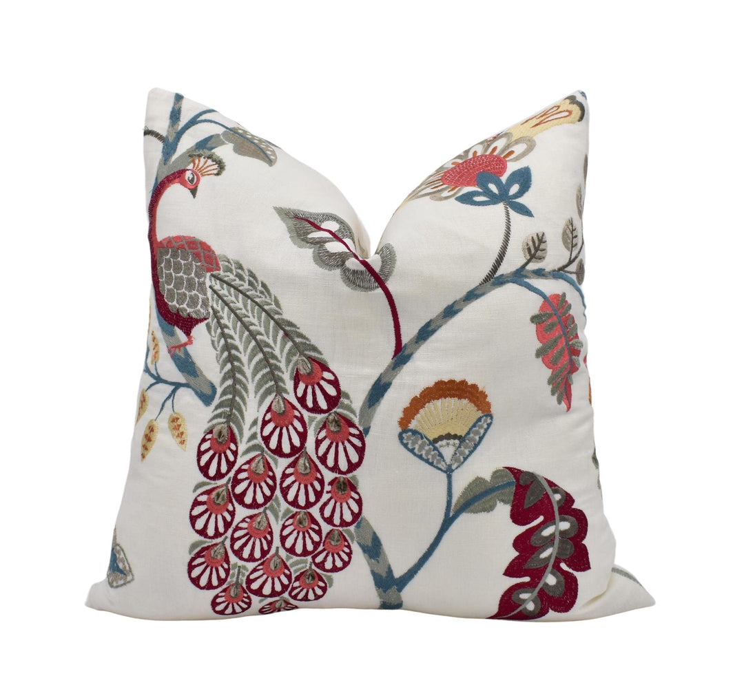 a decorative white pillow with a vibrant floral pattern.