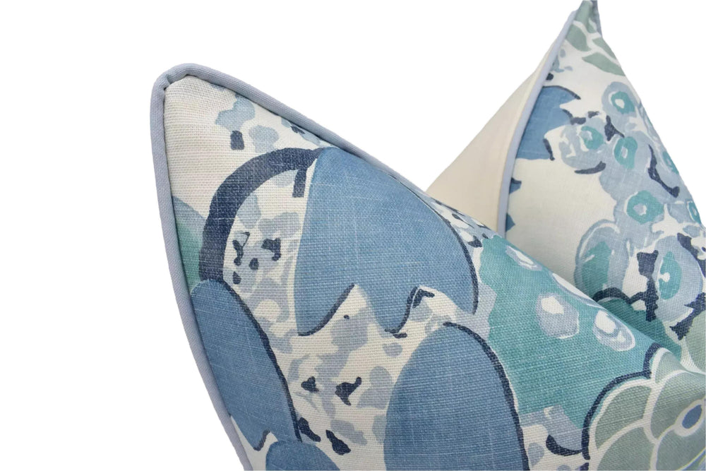 a close-up view of two decorative pillows with a floral pattern in shades of blue and white.
