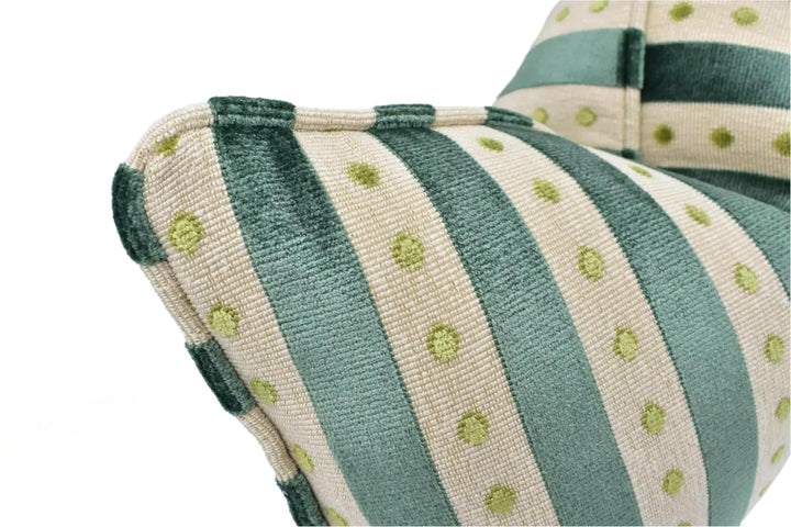 a close-up view of a green and white striped cushion with polka dots.
