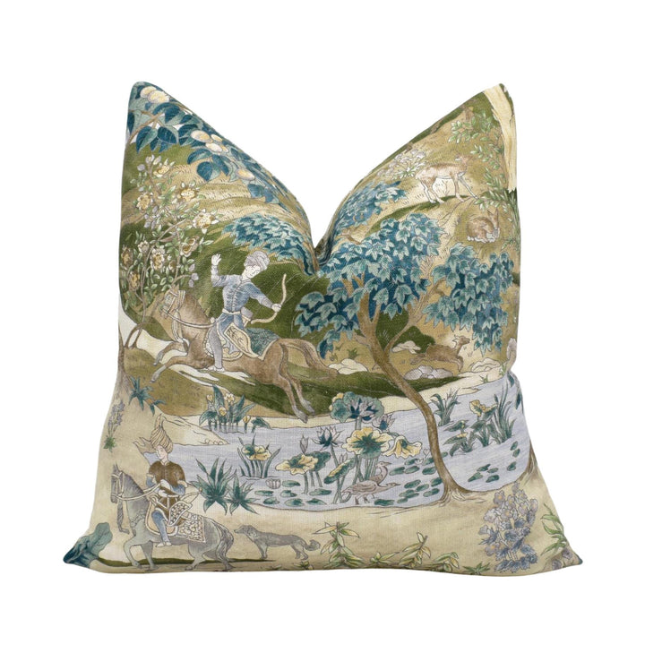 a decorative pillow with a detailed embroidered scene depicting a man riding a horse through a lush, forested landscape.