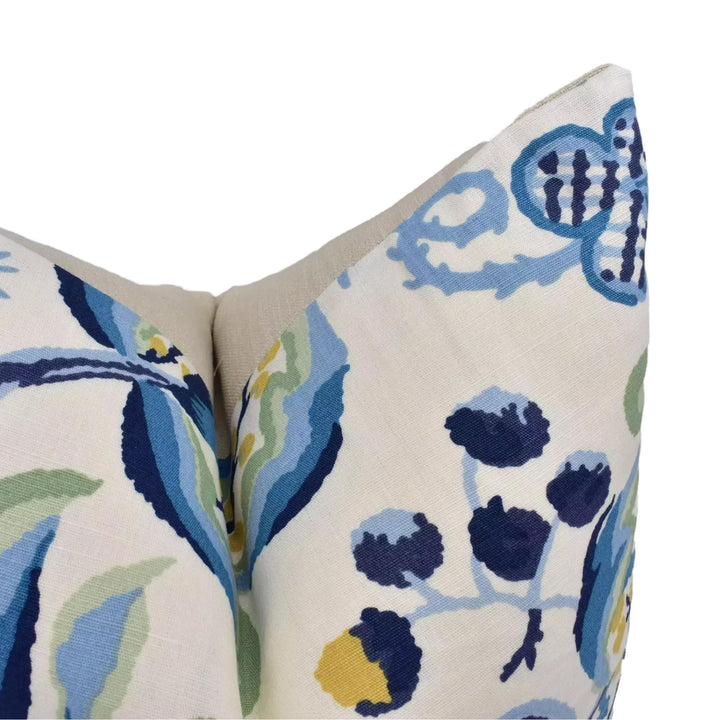 a close-up view of a decorative pillow with a floral pattern in shades of blue and green.