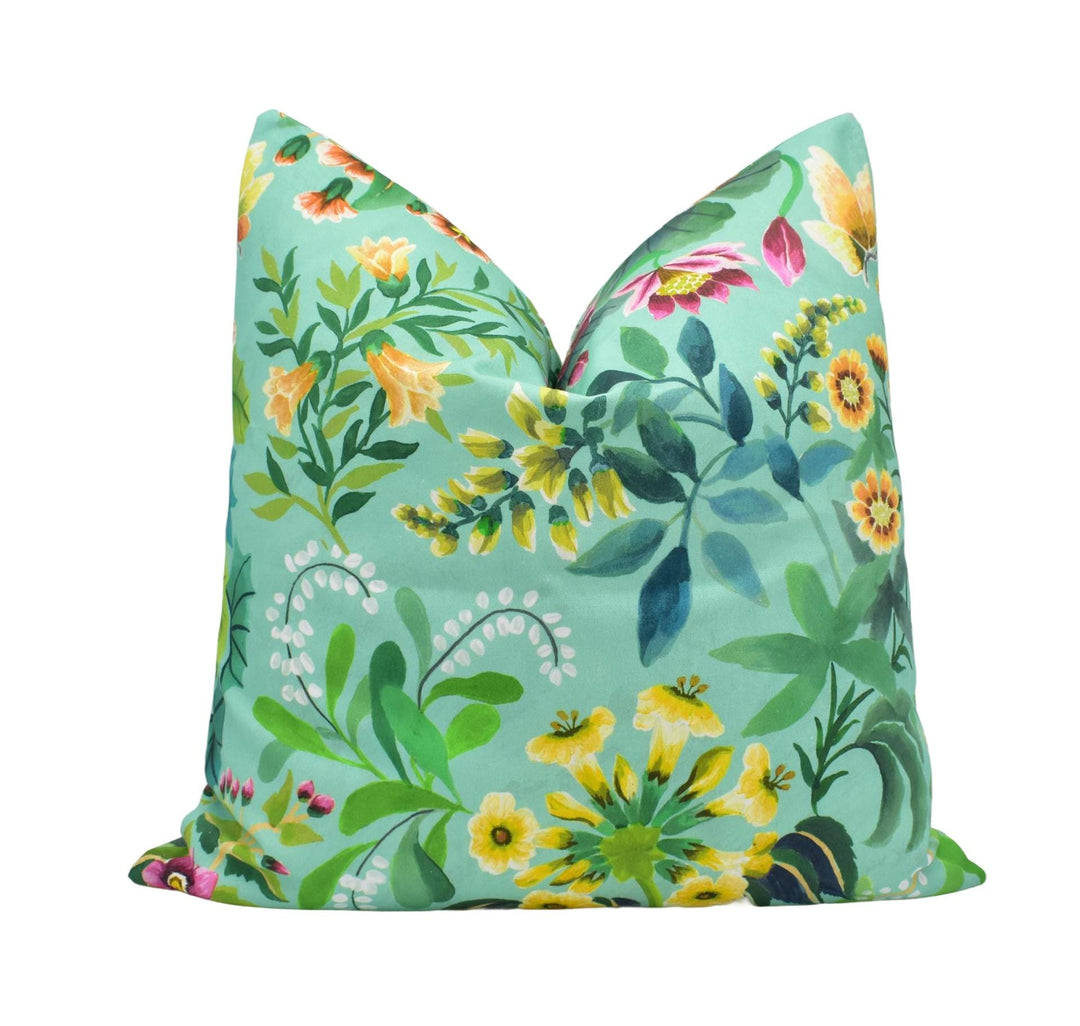 a green pillow with yellow and pink flowers on it