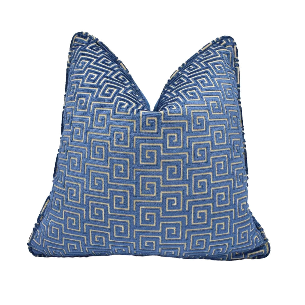 A blue and gold throw pillow with a repeating geometric pattern.