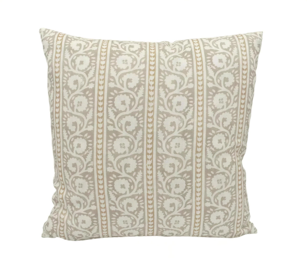 A decorative throw pillow with a repeating pattern of white and beige floral designs.