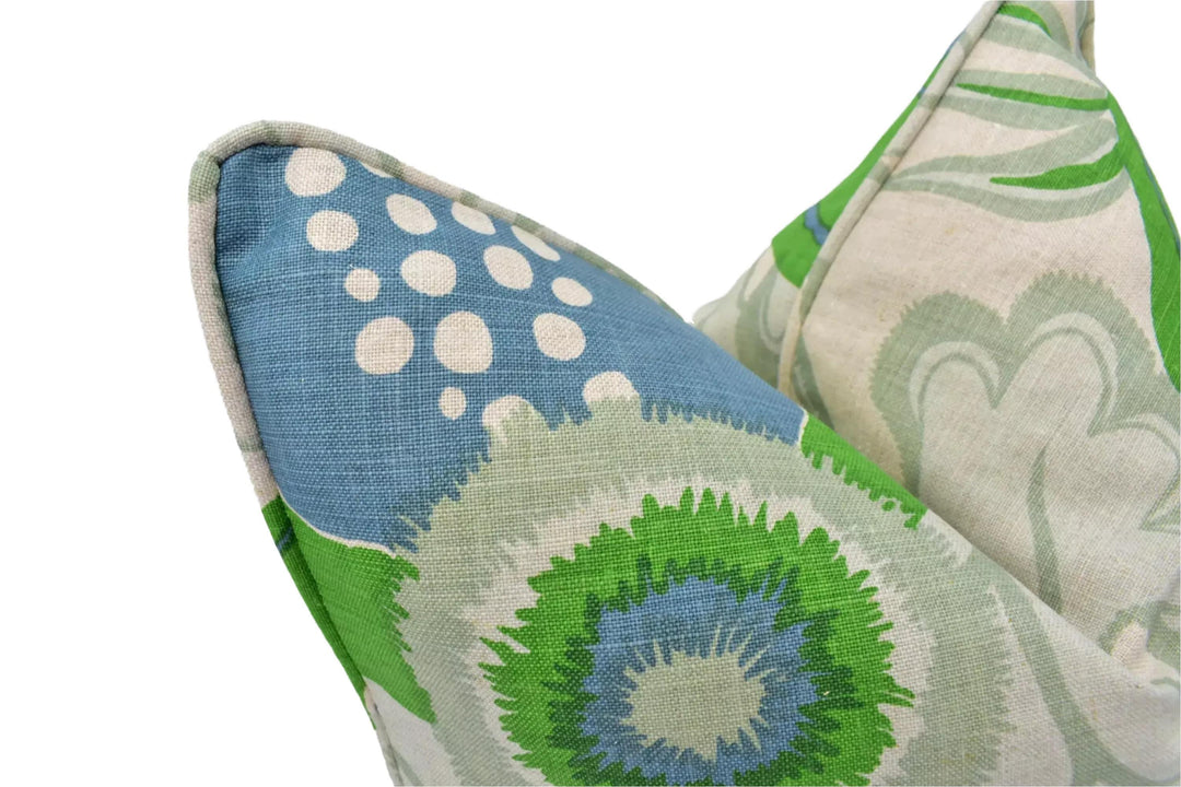 a close-up view of a decorative pillow with a vibrant, colorful floral pattern in shades of blue, green, and white.