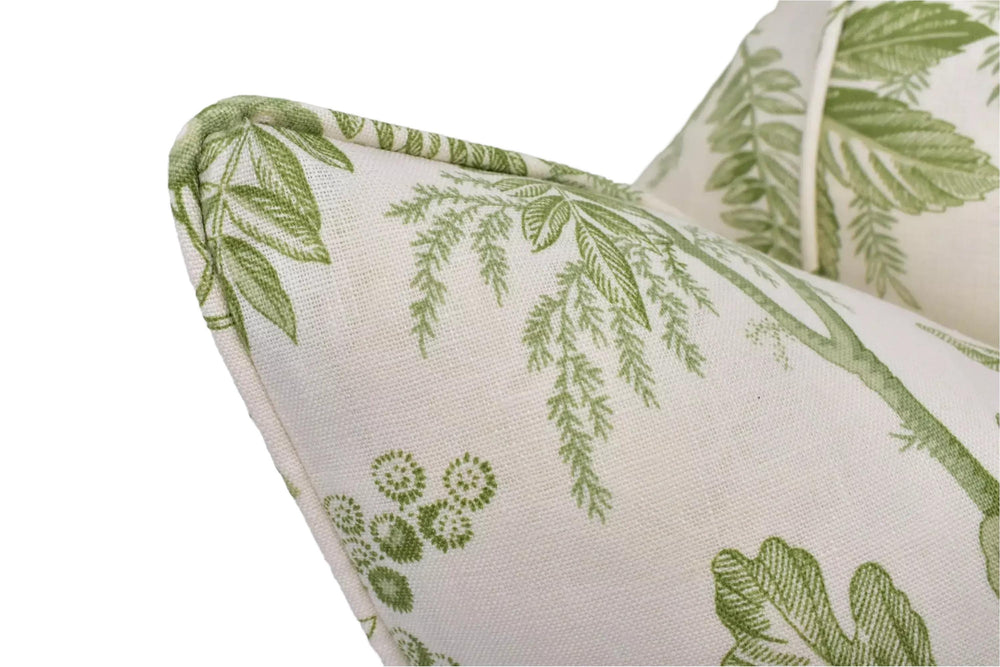 a close-up view of a white fabric with a green leaf pattern, featuring a curved edge and a floral design.