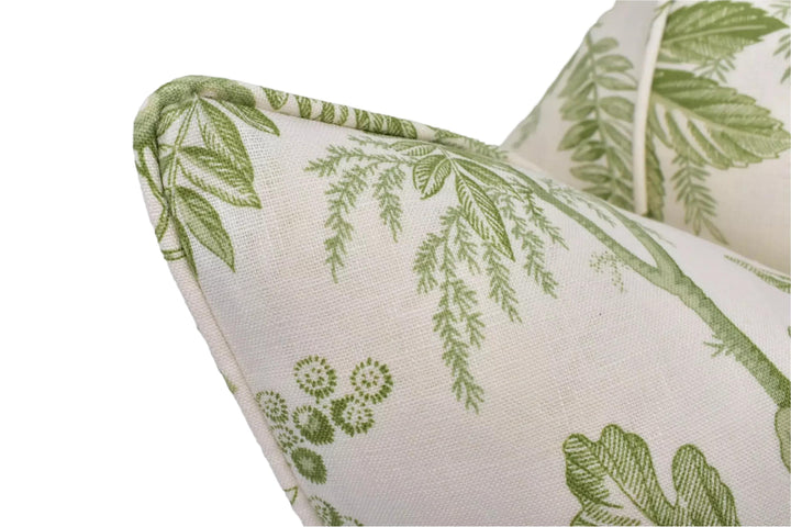 a close-up view of a white fabric with a green leaf pattern, featuring a curved edge and a floral design.