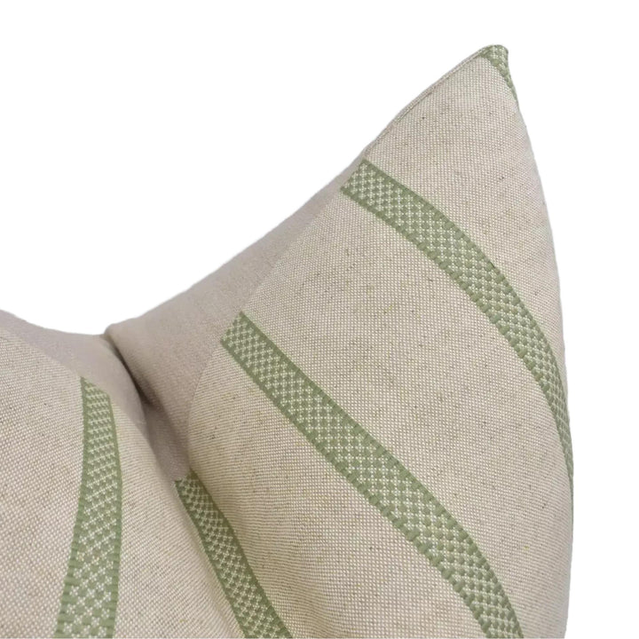 A close-up view of a beige fabric with green diagonal stripes, creating a textured and patterned appearance.
