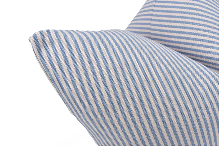 A close-up view of a blue and white striped pillow, with the fabric pattern clearly visible.