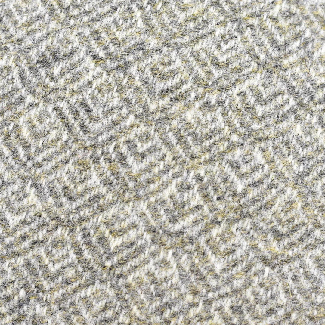 a close-up view of a textured fabric with a repeating pattern of gray and yellow geometric shapes.