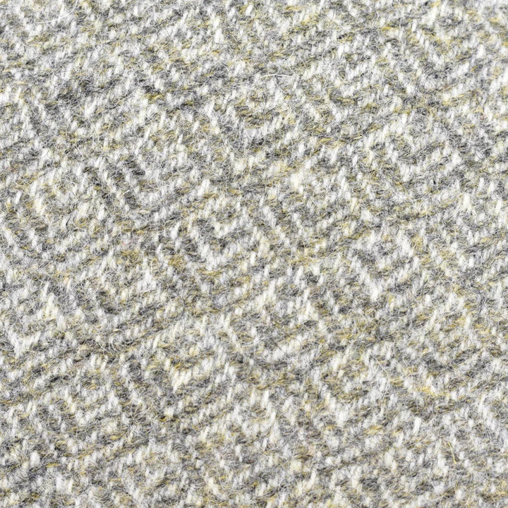 a close-up view of a textured fabric with a repeating pattern of gray and yellow geometric shapes.