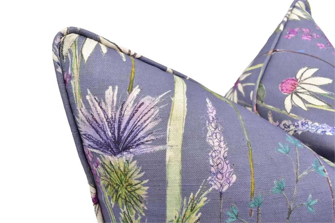 a close-up view of a decorative pillow with a floral pattern in shades of purple and green.