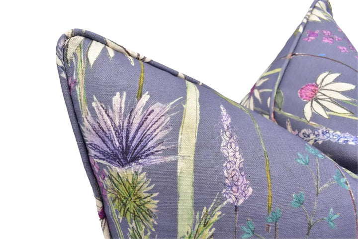 a close-up view of a decorative pillow with a floral pattern in shades of purple and green.