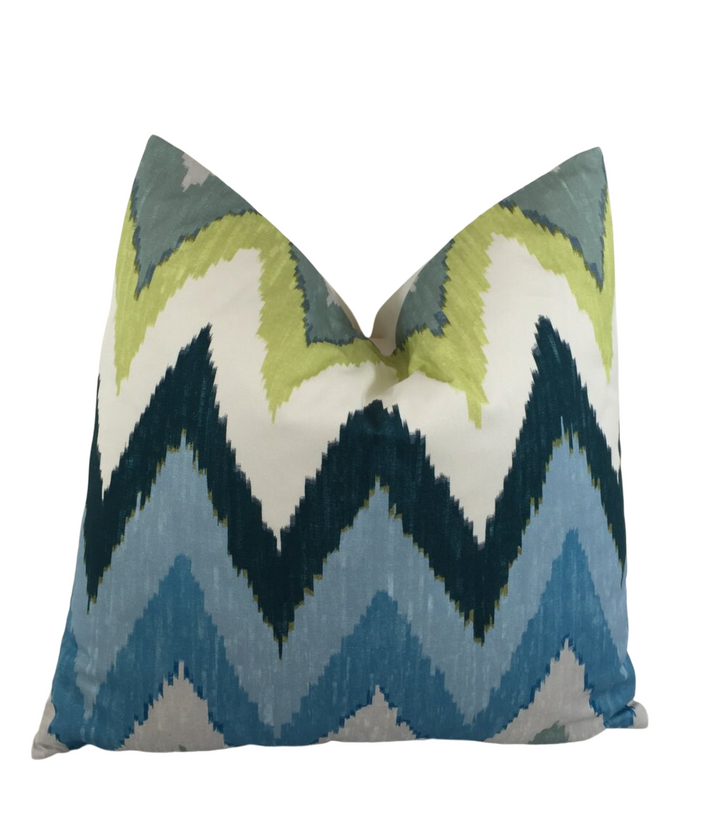a blue and green pillow on a white background