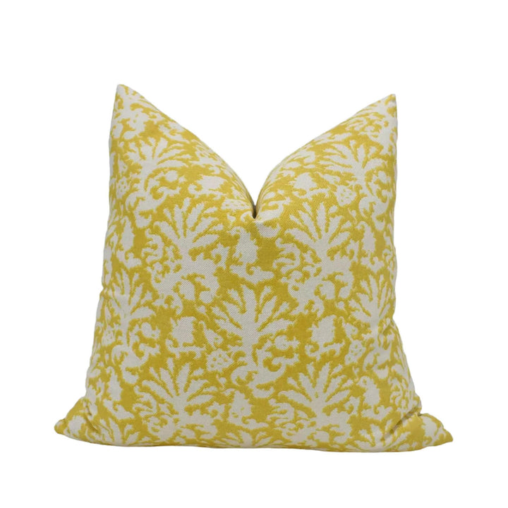 A yellow and white patterned throw pillow is shown against a white background.