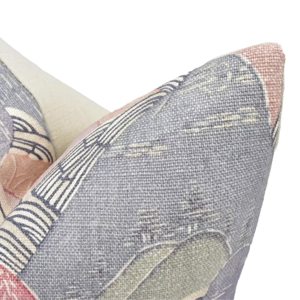 a close-up view of a decorative pillow with a textured, woven pattern in shades of blue, pink, and gray.