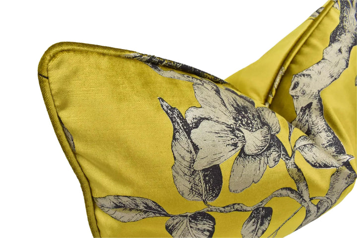 A close-up view of a yellow fabric with a black and white floral pattern, featuring a detailed illustration of flowers and leaves.