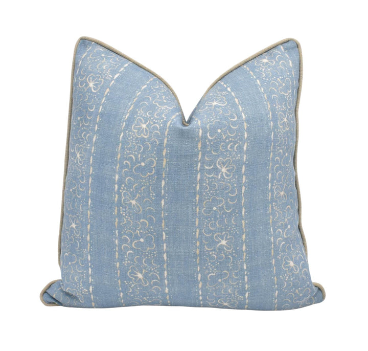 A blue and white striped throw pillow with a scalloped edge.