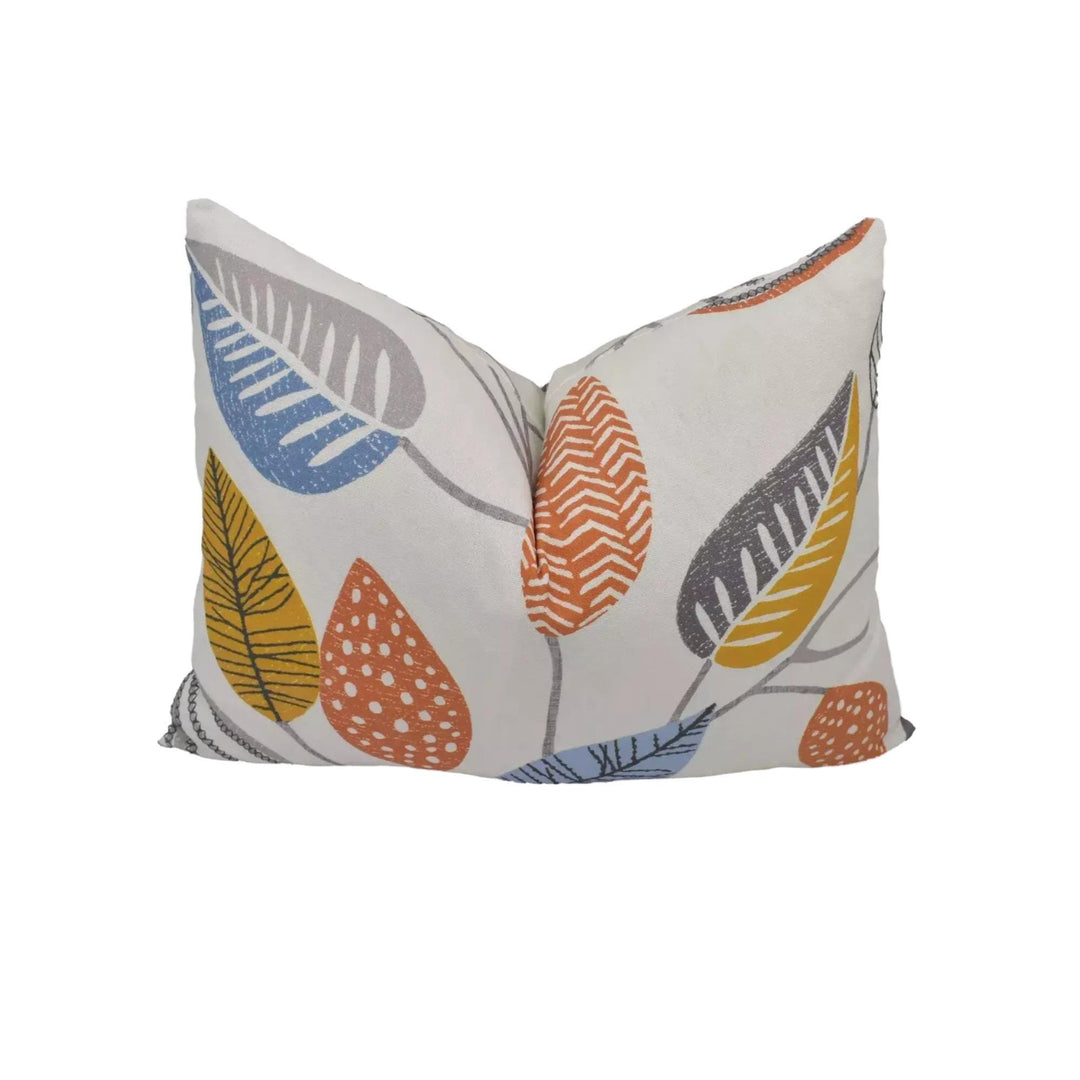 a white pillow with a colorful leaf pattern printed on it.