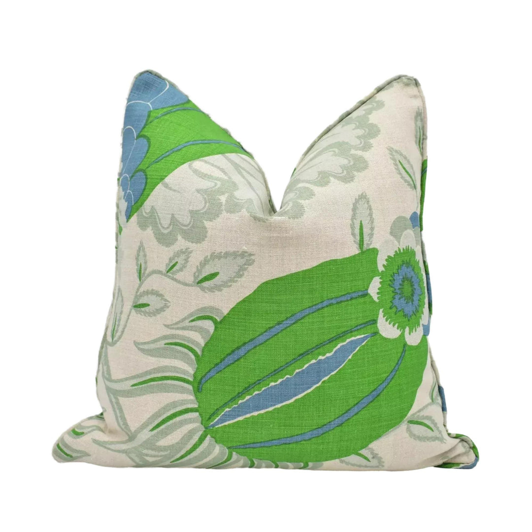 A decorative pillow with a floral pattern in shades of green and blue.