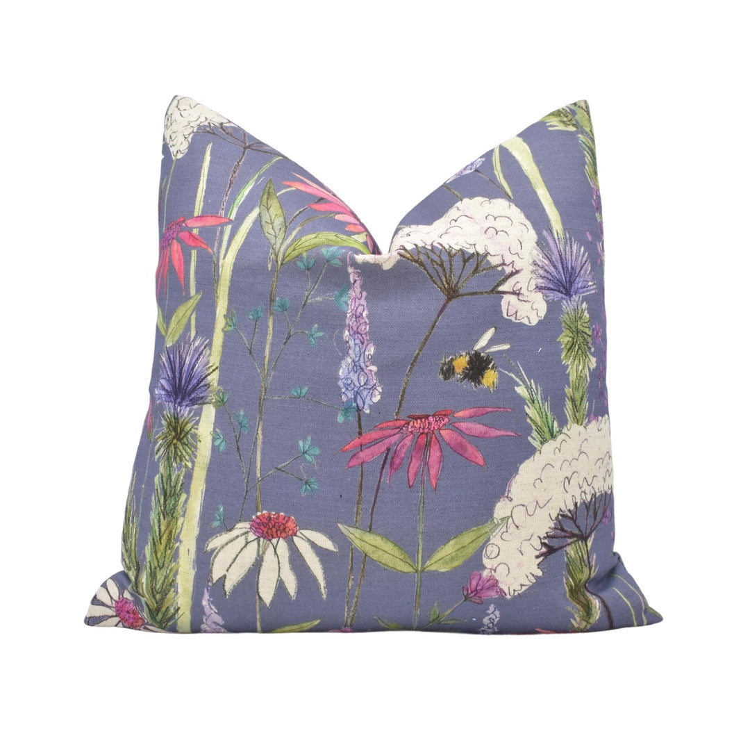 a blue pillow with flowers and a bee on it