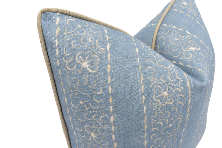 A close-up image of a blue and white patterned pillow with a floral design.