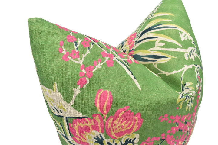 a close-up view of a green fabric with a floral pattern, featuring pink and green flowers and leaves.