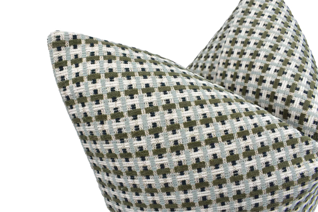 A close-up view of a decorative pillow with a geometric pattern in shades of green and gray.