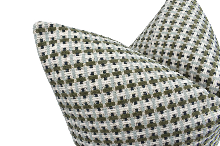 A close-up view of a decorative pillow with a geometric pattern in shades of green and gray.