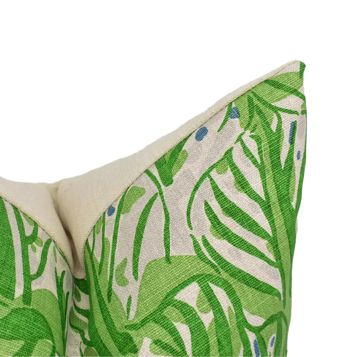 a close-up view of a green and white patterned fabric, possibly a pillow or cushion, with a leafy, tropical design.