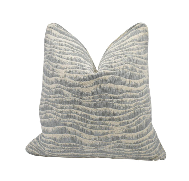 a gray and white striped pillow with a textured pattern.