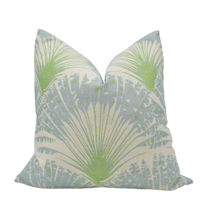 A decorative throw pillow with a light blue and green leaf pattern.