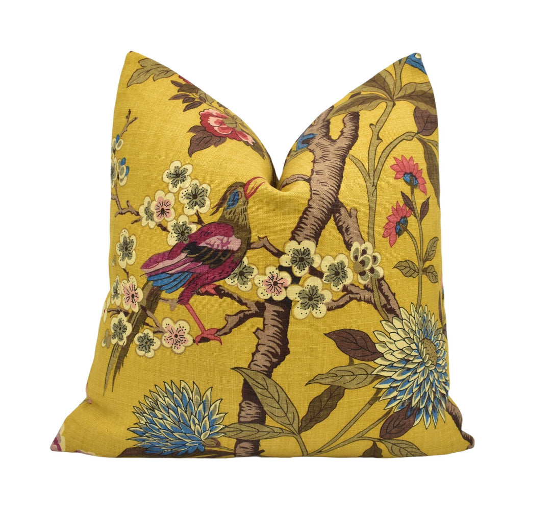 a yellow pillow with a colorful bird on it