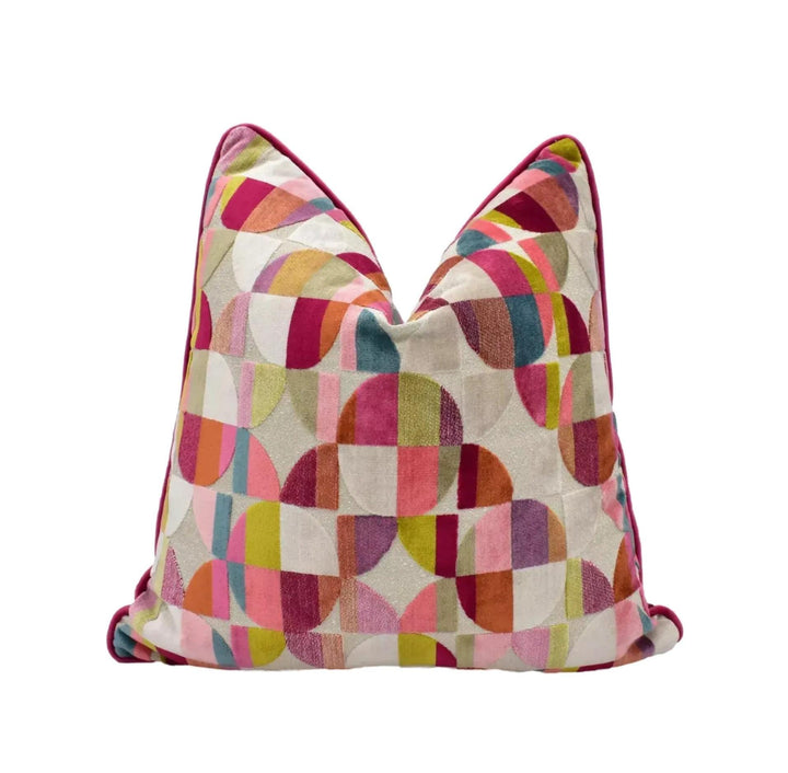 A colorful, geometric pillow with a pattern of overlapping circles in various shades of pink, red, orange, yellow, green, blue, and purple.