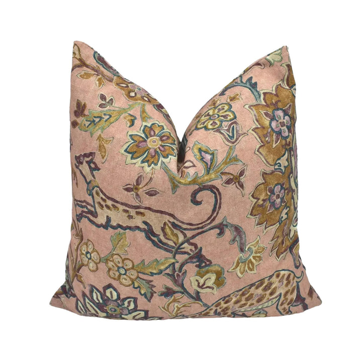 A decorative pillow with a floral pattern in shades of pink and green.