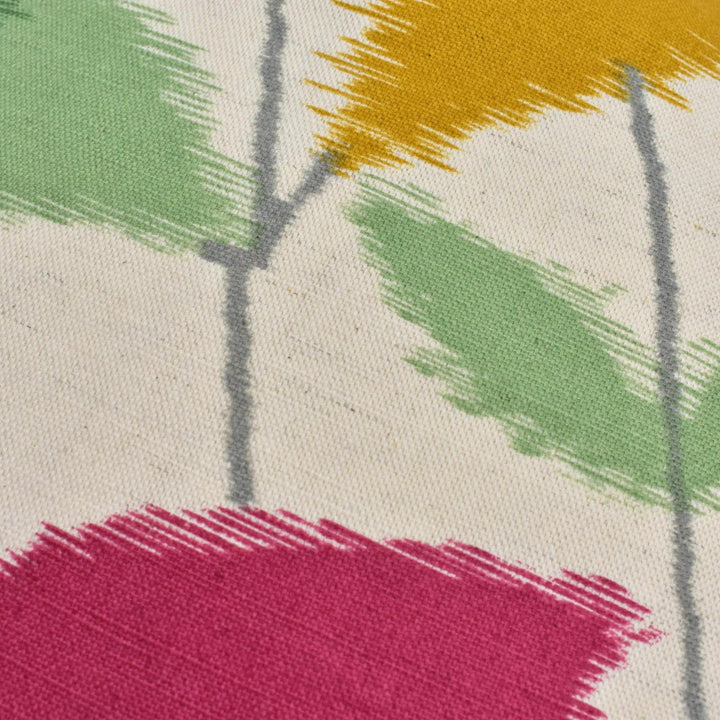 a close-up view of a colorful fabric with a pattern of green, yellow, and pink brushstrokes.