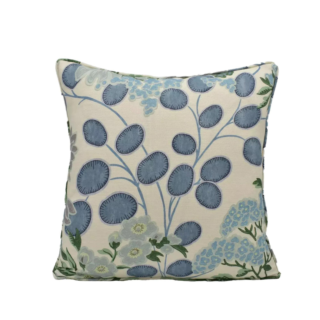 A square throw pillow with a floral pattern in shades of blue and green.
