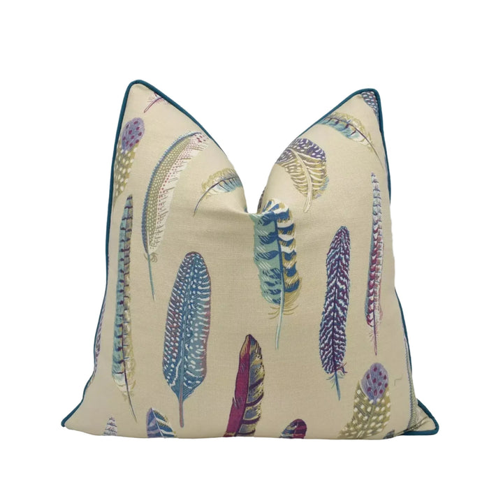 a beige pillow with a pattern of colorful feathers on it.