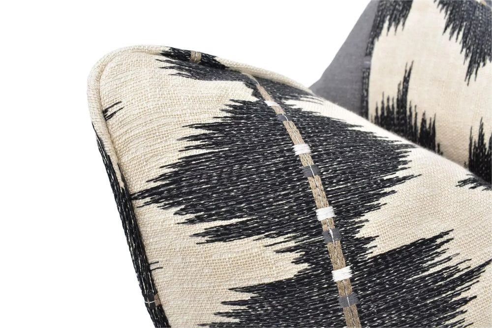 a close-up view of a black and white patterned fabric, possibly a pillow or cushion, with a textured and woven appearance.
