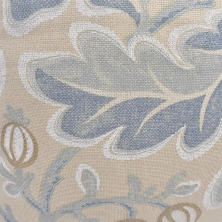 a close-up view of a fabric with a floral pattern in shades of blue and beige. The pattern features a large leaf-like shape in the center, surrounded by smaller leaf-like shapes and flowers in various shades of blue and beige.