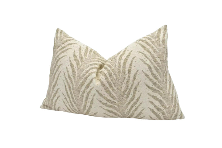 A beige and gold zebra print pillow is placed against a white background.