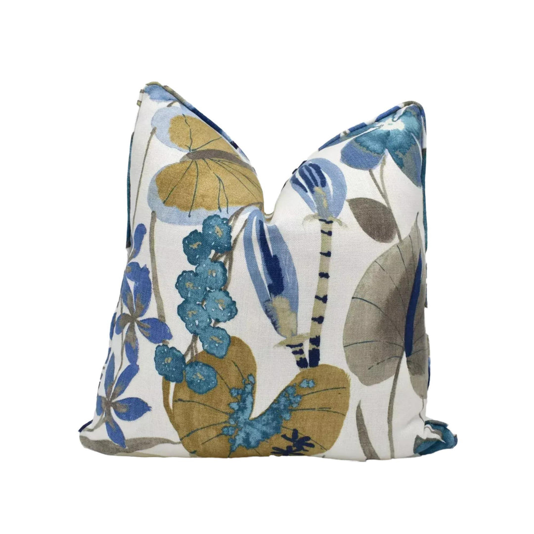 a decorative pillow with a floral print in shades of blue, green, and yellow.
