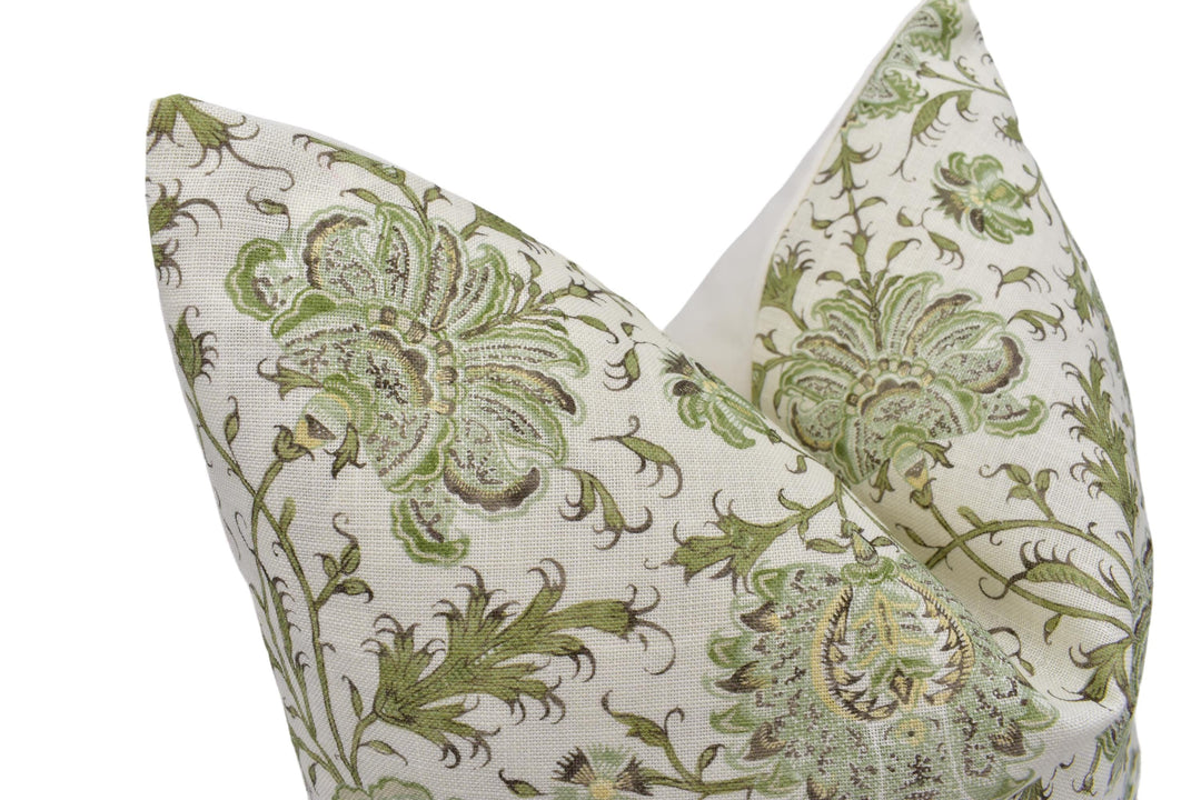 a green and white pillow with a flower design